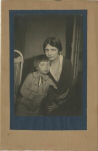 Photographie en noir et blanc de Jean Blot, jeune enfant avec sa mère, collée sur deux cartons superposés.Crédit image : Archives Jean Blot / IMEC